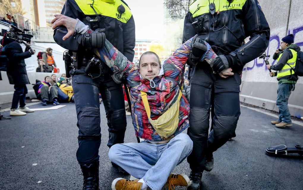 De politie grijpt in tijdens de demonstratie van klimaatactiegroep Extinction Rebellion bij de A12. beeld ANP, MARCO DE SWART