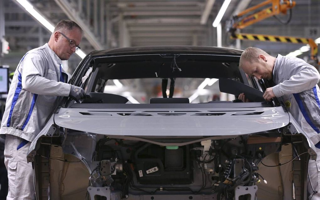 Monteurs sleutelen aan een ID.3. Het eerste exemplaar van het elektrische model van Volkswagen rolde maandag in Zwickau van de band. beeld AFP, Ronny Hartmann