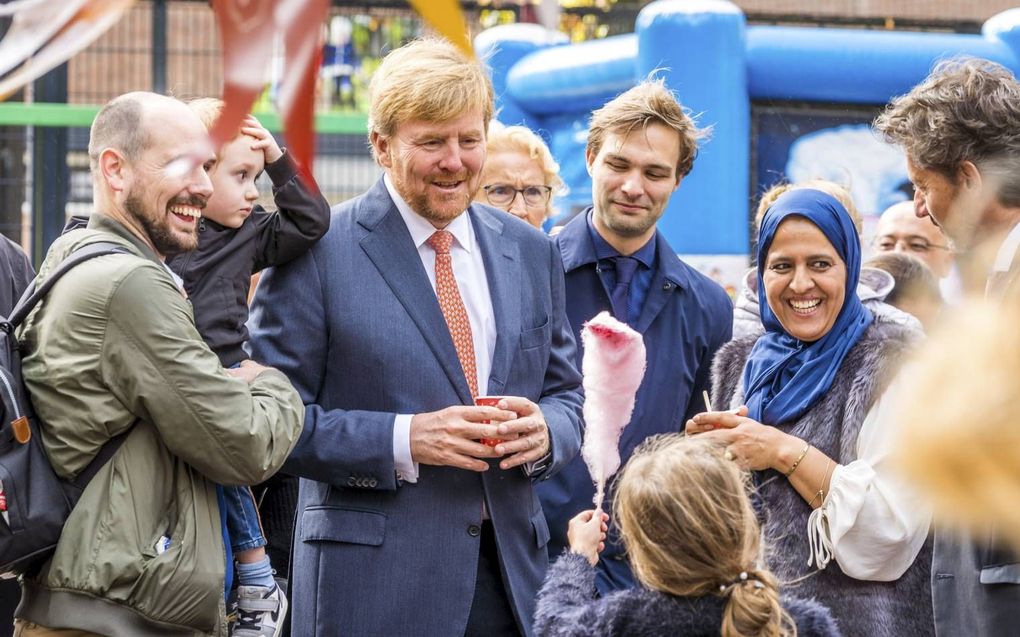 „In de buurt sta je voor elkaar klaar.” Foto: koning Willem-Alexander in gesprek met bewoners bij de start van Nationale Burendag in 2019. beeld ANP, Lex van Lieshout