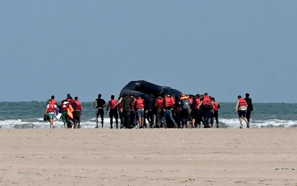 Migranten duwen een opblaasbare boot in zee bij Gravelines, in het noorden van Frankrijk, 25 augustus. Ze behoren bij de velen die een poging doen de oversteek naar Groot-Brittanië te maken. beeld AFP, Denis Charlet