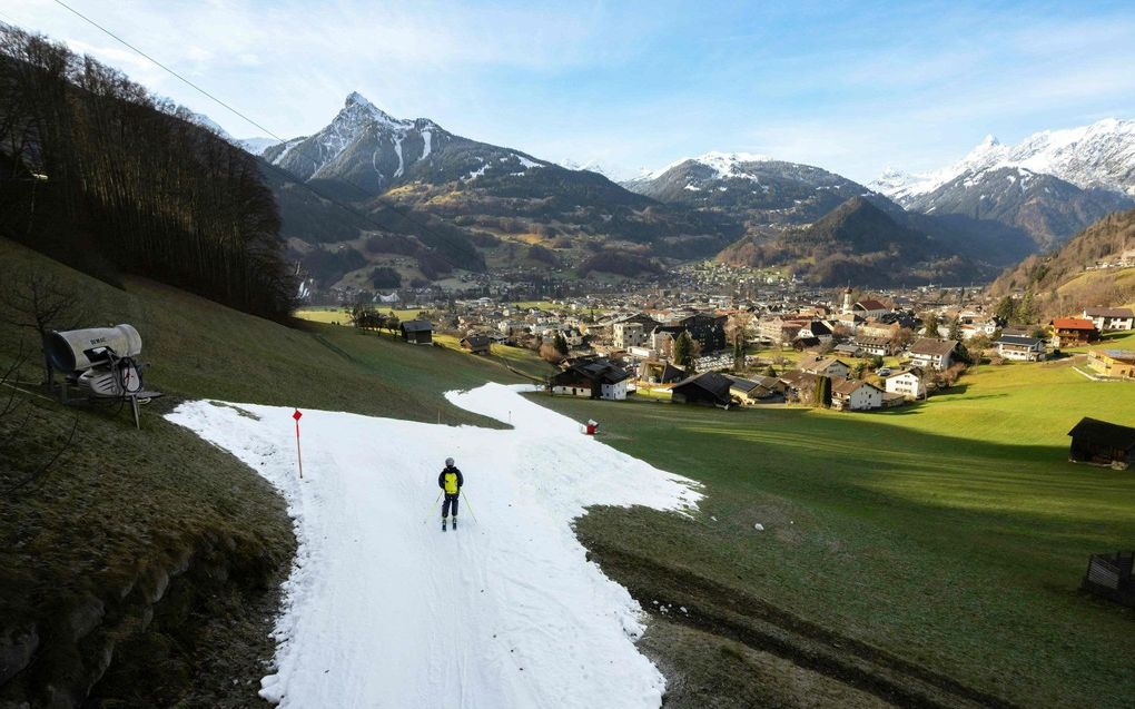 Een skiër op een piste in het Oostenrijkse Schruns. In andere jaren lag rondom de piste ook volop sneeuw. beeld AFP, Dietmar Stiplovsek