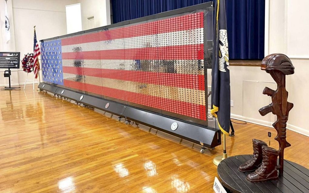 Het tijdelijke Fallen Heroes Memorial bestaat uit 7063 rode, zilveren en blauwe hondenpenningen die samen de Amerikaanse vlag vormen. beeld VAU