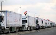Een colonne trucks met humanitaire goederen wacht bij de grens met Egypte om doorgelaten te worden. Israël controleert alle vrachtwagens die Gaza binnengaan. beeld EPA, Khaled Elfiqi