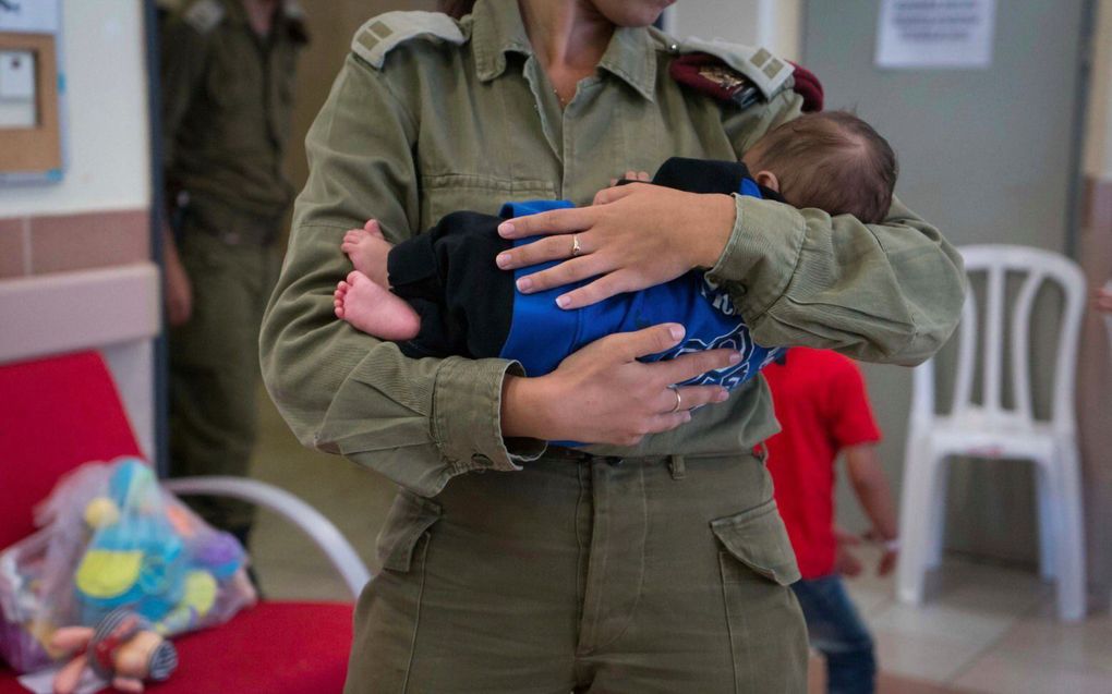 Een Israëlische militair ontfermt zich over een Syrische baby in een veldhospitaal bij de Syrische grens. beeld Israel Defense Forces