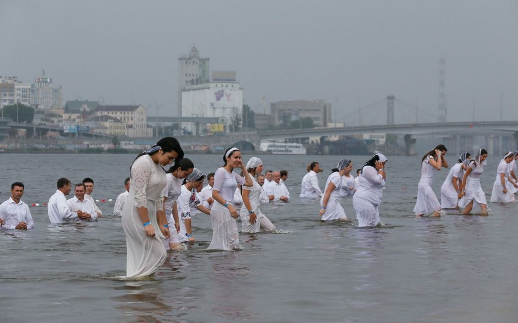 Veel baptisten in Rusland en Oekraïne zijn vanouds pacifistisch. Foto: doopdienst in de rivier bij Kiev.  beeld EPA, Sergey Dolzhenko