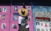 Moeders en andere familieleden van verdwenen personen plaatsen foto’s van hun geliefden op hekken in het centrum van Mexico-Stad. Ze eisen dat de autoriteiten hun vermiste familieleden opspoort en nieuwe vermissingen voorkomt. beeld EPA, Mario Guzman