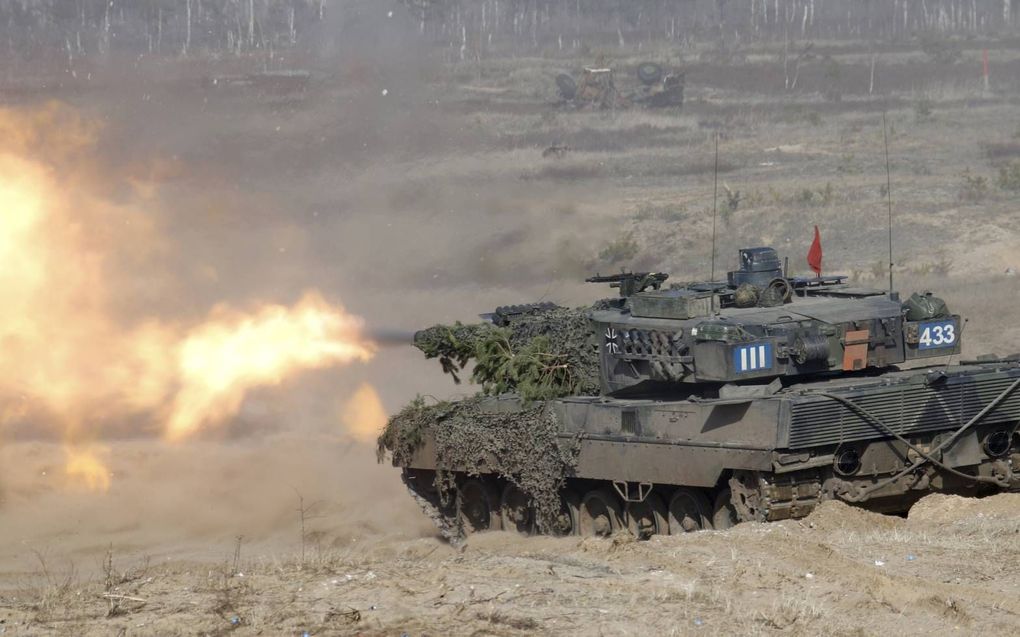 Een grote steekvlam, een doffe dreun. Voltreffer! Gehuld in een grote stofwolk, gemengd met een zwarte dieselwalm, rijdt een Leopard 2A6-gevechtstank over militair oefenterrein. De Leopardtanks die de Koninklijke Landmacht in bruikleen heeft, rijden ruim 3 op 1. Dat is geen ecologische voetafdruk om over naar huis te schrijven. beeld EPA, Valda Kalnina