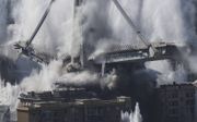 De belangrijkste pijlers van de brug in Genua storten in. Duizenden mensen werden geëvacueerd om de brug te vernietigen. Gezien de stofwolken, hebben de woningen nog wel een schoonmaakbeurt nodig. beeld EPA, Luca Zennaro