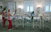 Oekraïense verpleegkundigen zorgen voor baby’s tijdens de coronacrisis. Door reisbeperkingen was het voor veel cliënten niet mogelijk hun kind op te halen. beeld AFP, Sergei Supinsky