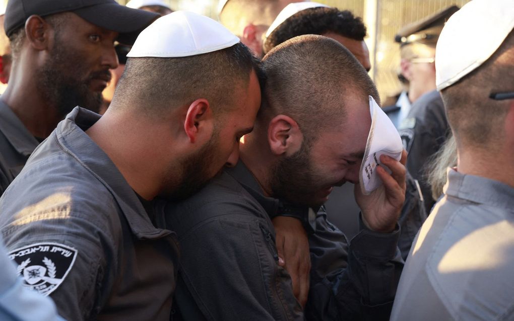 Nabestaanden wonen een begrafenis bij van een Israëli die vermoord werd in Kibbutz Reim. beeld AFP, Menahem Kahana