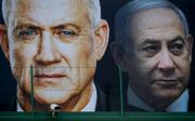 Banner met de leider van Blauw-Wit, Benny Gantz (l.) en premier Benjamin Netanyahu (r.) in de Israëlische plaats Ramat Gan, februari. beeld AFP, Jack Guez