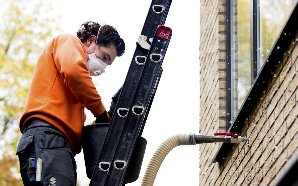 Kopers van een energiezuinige woning kunnen extra lenen. Foto: het isoleren van een woning. beeld ANP, Koen van Weel