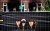 Bloemen bij het pand aan het Rotterdamse Heiman Dullaertplein waar Fouad L. een 39-jarige buurvrouw en haar 14-jarige dochter om het leven bracht en brand stichtte. beeld ANP, Jeffrey Groeneweg