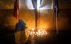 Een vrouw gehuld in de nationale vlag van Oekraïne steekt een kaars aan bij een gedenkteken voor de vermoorde onderzoeksjournalist Jan Kuciak en Martina Kusnirova als reactie op de uitslag van de vervroegde parlementsverkiezingen in Bratislava, Slowakije. beeld AFP, VLADIMIR SIMICEK