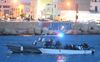 Een Italiaanse patrouilleboot begeleidt een vaartuig met migranten dat aankomt in de haven van Lampedusa. beeld EPA, Ciro Fusco