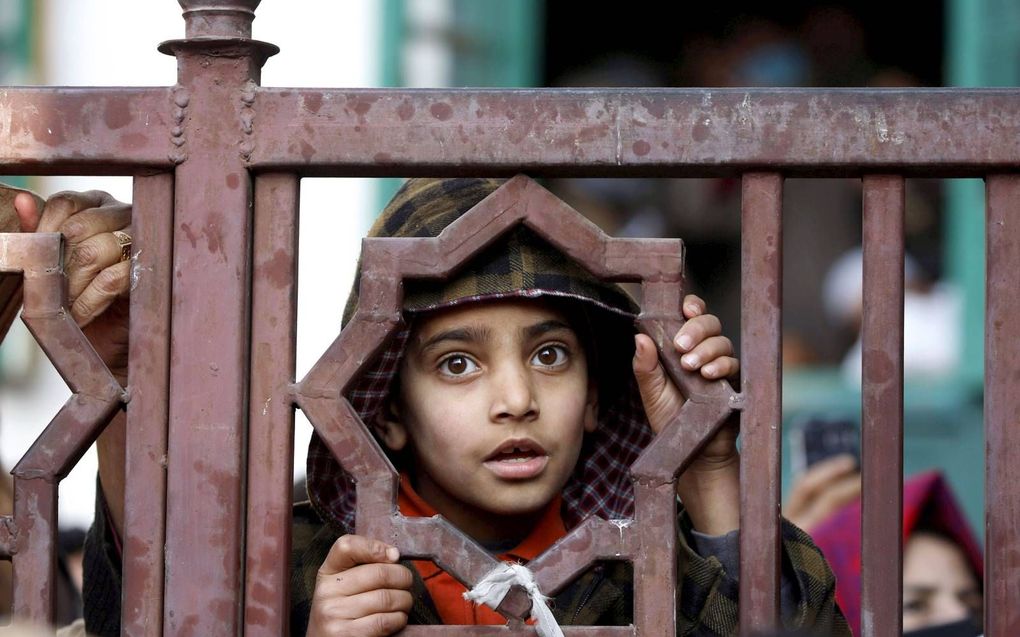 Een islamitisch jongetje in Srinagar, het Indiase deel van Kashmir, luistert naar een moslimgeestelijke. beeld EPA, Farooq Khan