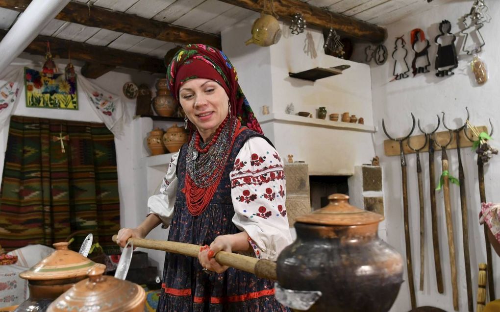 Olena Shcherban, een Oekraïnse volkenkundige en historica, kookt in traditionele kledij borsjtsj. Shcherban deed onderzoek naar het gerecht en verzamelde in heel Oekraïne 365 originele recepten ervan. beeld AFP, Genya Savilov