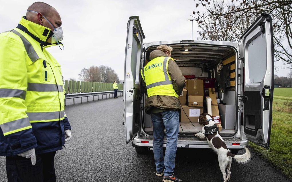 Medewerkers van Inspectie Leefomgeving en Transport gebruiken een vuurwerkhond tijdens een wegcontrole vuurwerk en personenvervoer langs de A12 ter hoogte van Babberich in de gemeente Zevenaar. beeld ANP SEM VAN DER WAL