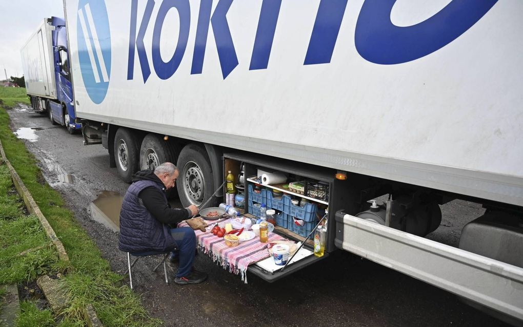 Een Turkse vrachtwagenchauffeur maakte dinsdagmorgen zijn ontbijt klaar bij een vrachtwagenstopplaats langs de snelweg M20 die naar de haven van Dover in Zuidoost-Engeland leidt. Hij is een van de vele truckers die in de rij staat en niet over kan steken naar Frankrijk. beeld AFP, Justin Tallis