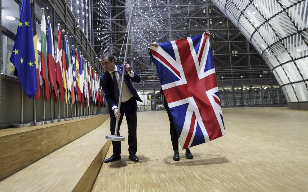 Medewerkers van de Europese Raad in Brussel verwijderen op 31 januari 2020 de Britse vlag. Het Verenigd Koninkrijk zat vanaf dat moment tot en met 31 december in een overgangsperiode. beeld EPA, Olivier Hoslet