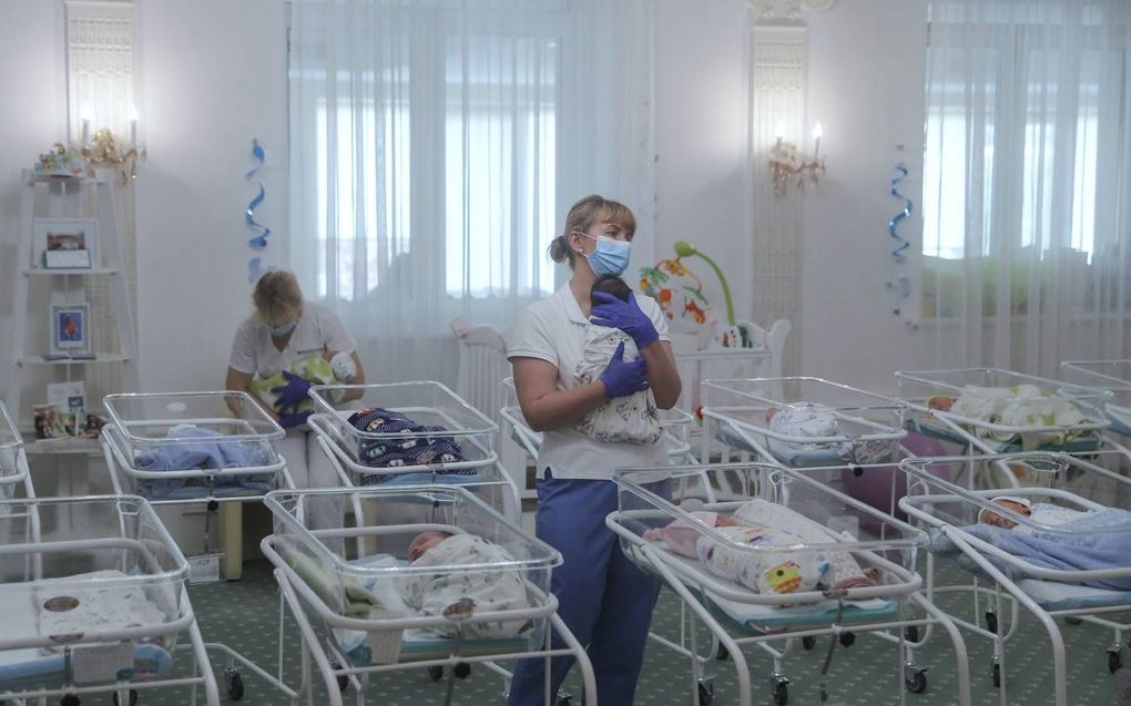 Verpleegkundigen zorgen in mei 2020 voor pasgeboren baby’s in een hotel in Kiev, Oekraïne. Zo’n vijftig draagmoederbaby’s wachten op hun buitenlandse ouders. De wensouders kunnen echter het land niet in omdat de grenzen van Oekraïne zijn gesloten vanwege de uitbraak van het coronavirus. beeld EPA, Sergey Dolzhenko