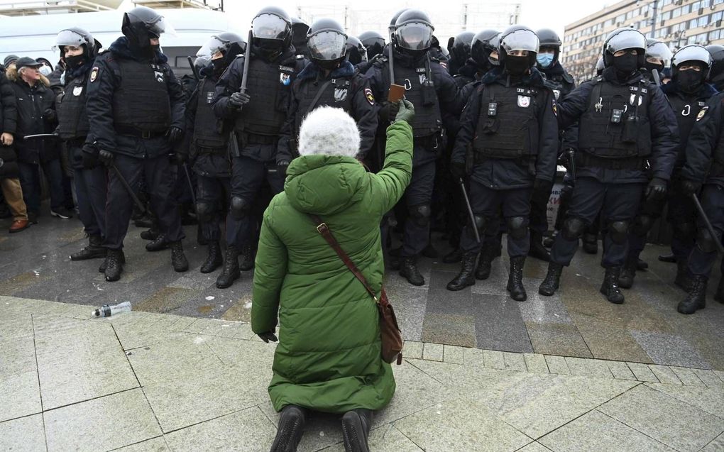 Russen hebben eerbied voor het heilige. Ook de leden van de oproerpolitie. Zolang deze vrouw haar ikoon omhoog houdt, heeft ze een kans er zonder kleerscheuren vanaf te komen.  beeld AFP, Kirill Kudryavtsev