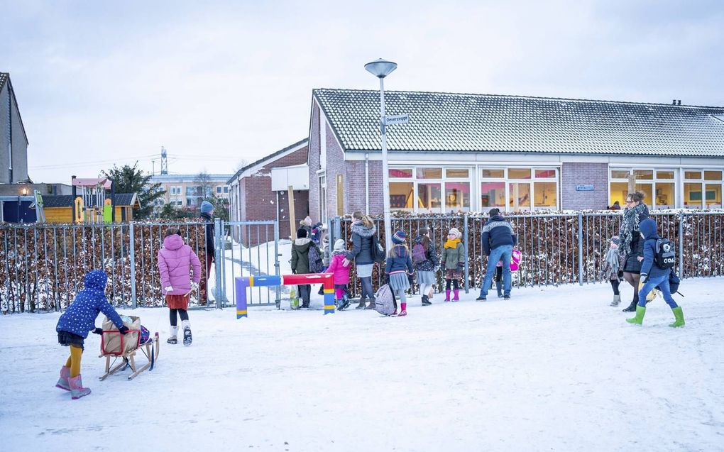 Kinden en ouders kwamen vanmorgen al glibberend en glijdend aan bij de Ds. Petrus van der Veldenschool in Nieuw-Lekkerland. beeld Cees van der Wal