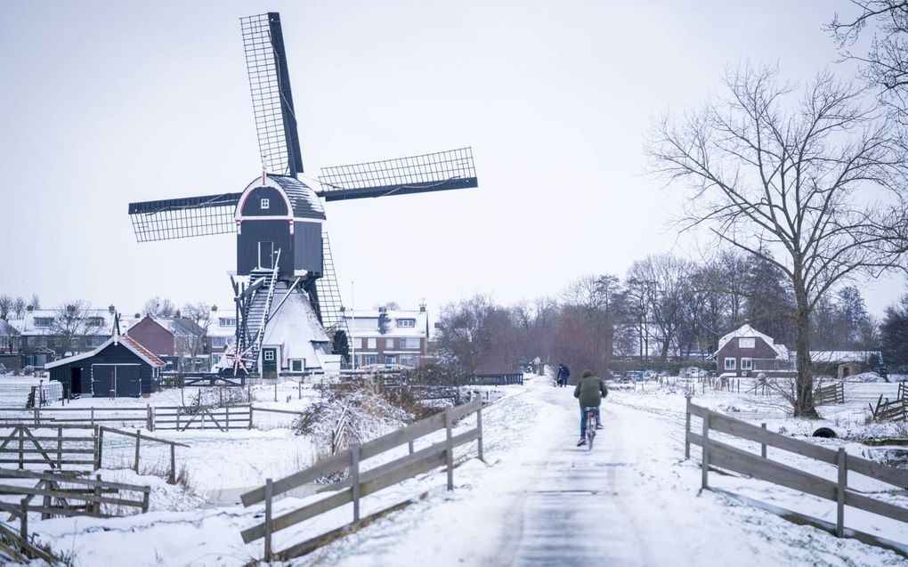 Nederland ligt onder een witte deken. De vrieskou houdt naar verwachting voorlopig aan. Foto: op de Tiendweg bij Streefkerk is het glibberen en glijden. beeld Cees van der Wal