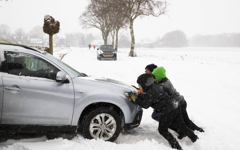 Een auto blijft steken in de sneeuw in het buitengebied bij het Overijsselse Haarle. De ANWB adviseert automobilisten rustig op te trekken. Banden krijgen op een glad oppervlakte namelijk moeilijker grip. beeld ANP, Vincent Jannink