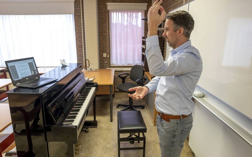 Muziekdocent Frans Nieuwenhuyzen van het Calvijn College oefent met zijn leerlingen uit vwo 5 verschillende dirigeertechnieken. beeld Dirk-Jan Gjeltema