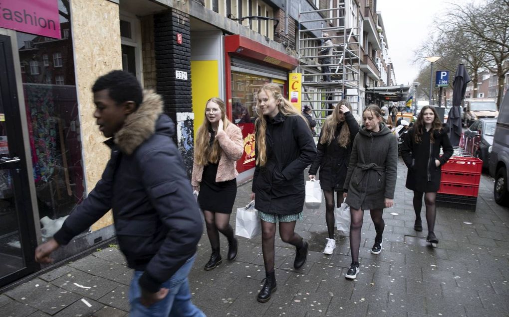Studenten van het Hoornbeeck College Rotterdam bezoeken winkeliers na de rellen in Rotterdam-Zuid. beeld RD