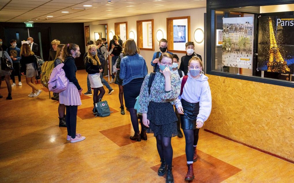 Leerlingen wachten in de gangen van het Wartburg College, locatie Guido de Brès in Rotterdam, op de bel. Vanaf 1 maart mogen middelbare scholieren en mbo-studenten weer minimaal een dag per week naar school. beeld Cees van der Wal