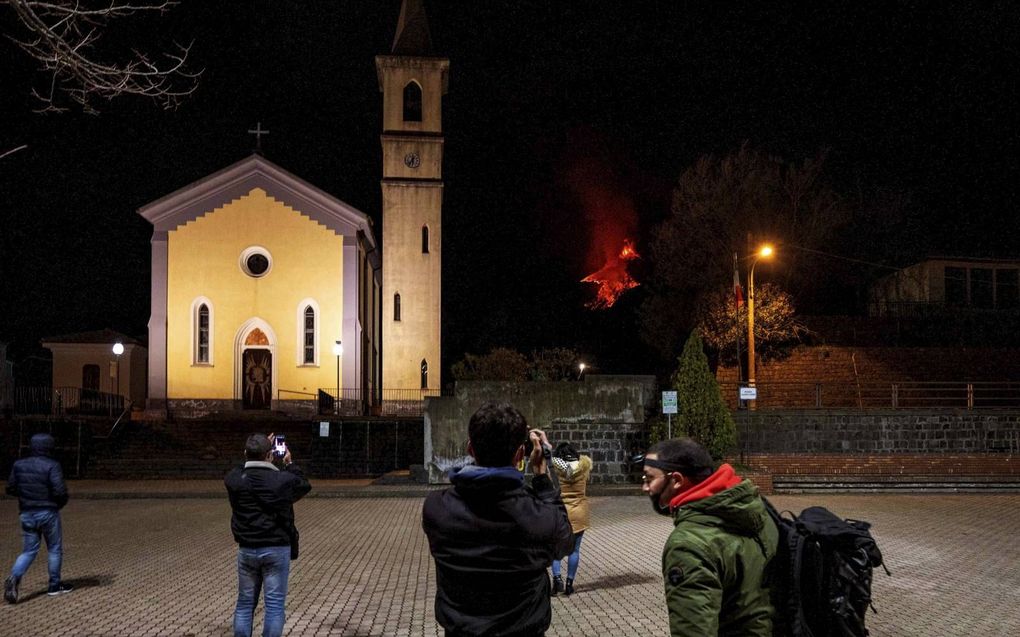 Inwoners van Zafferana Etnea op Sicilië nemen foto’s van de Etna, waar de gloeiende lava vanaf stroomt.  beeld AFP, Giovanni Isolino