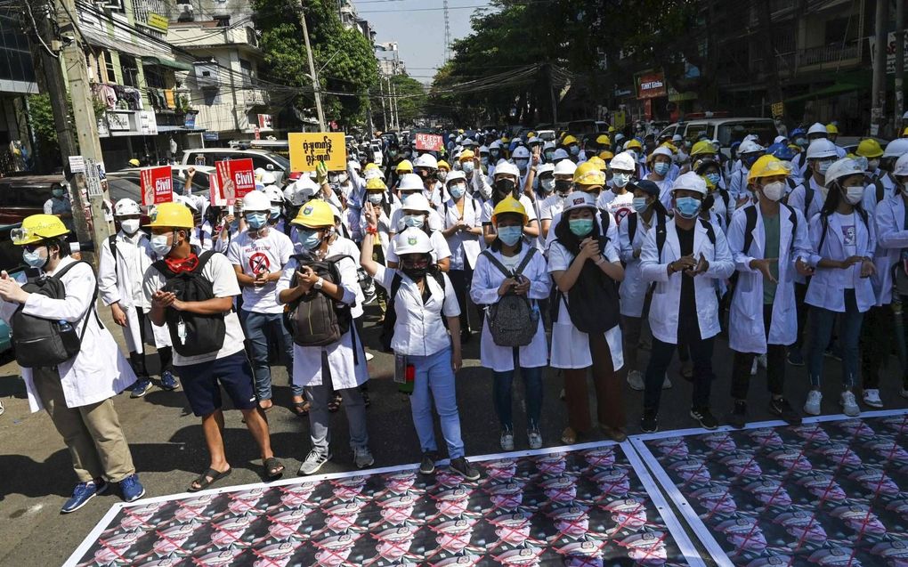 Ook vrijdag betoogden tegenstanders van de militaire coup in Myanmar  in de straten van onder andere Yangon.  Hier hebben  betogers foto's van legerleider Min Aung Hlaing  op straat gelegd. beeld STR, AFP