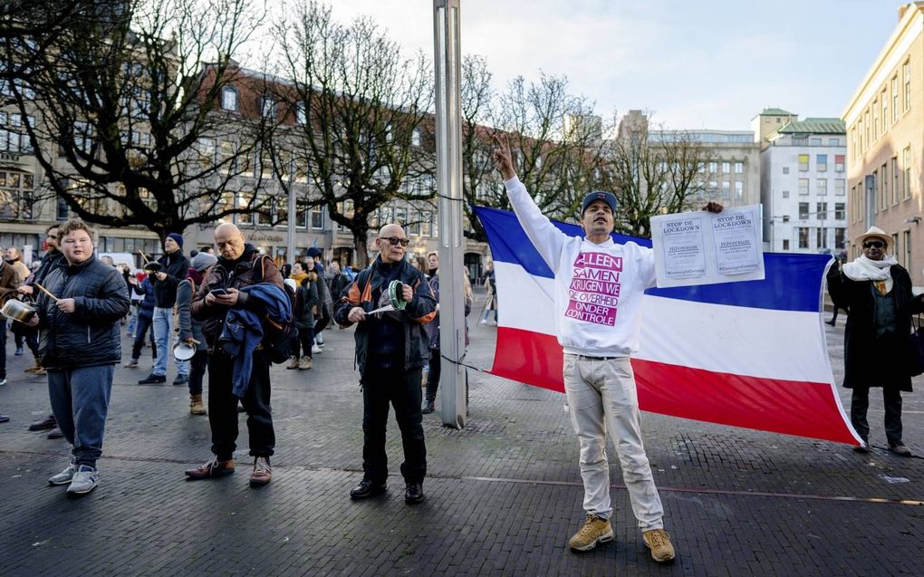 Aanhangers van de groep Viruswaarheid houden uit onvrede met de coronamaatregelen een Nederlandse vlag ondersteboven.  beeld ANP, Bart Maat