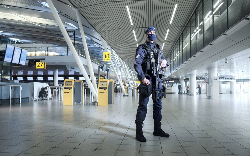 Met z’n HK 416 in de aanslag patrouilleert marechaussee Jordy dagelijks op Schiphol. Corona maakt het werk anders. „Niet minder leuk.” beeld Eran Oppenheimer