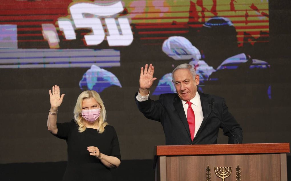 De Israëlische premier Netanyahu (r.) en zijn vrouw Sara (l.) waren woensdag al een beetje in feeststemming.   beeld  EPA, Abir Sultan