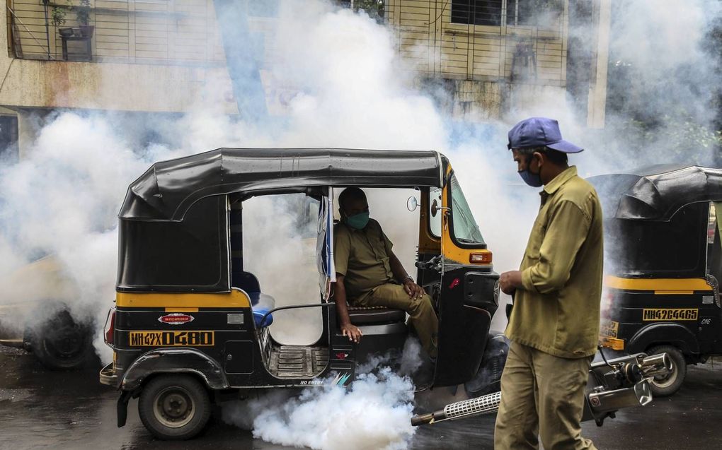 Een medewerker van de gemeente spuit in Mumbai, India, een bestrijdingsmiddel om te proberen elke vorm van ziekten veroorzaakt door muggen, waaronder malaria, te voorkomen. beeld EPA, Divyakant Solanki