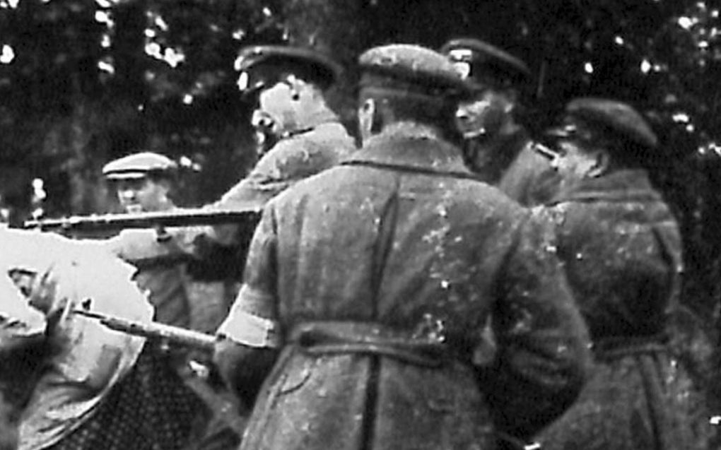 Twee Oekraïners en twee Duitsers vermoorden een Joodse vrouw en haar twee kinderen in Miropol (Oekraïne) in 1941 (detail van de originele foto). beeld Security Services Archive