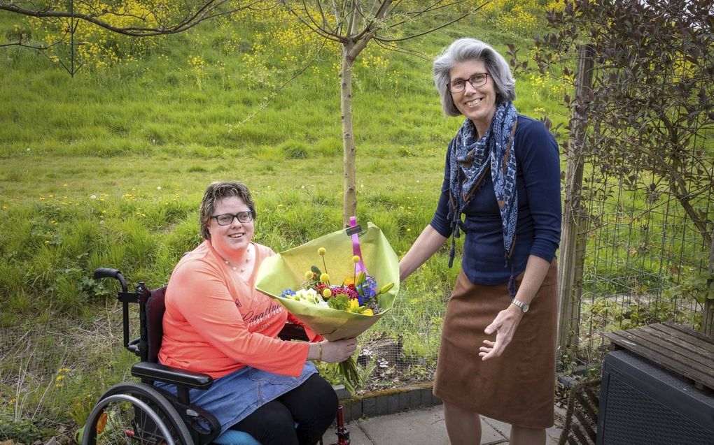 Annemieke Huijzer overhandigt een bloemetje aan haar vriendin Wilma Kooij. beeld RD, Anton Dommerholt