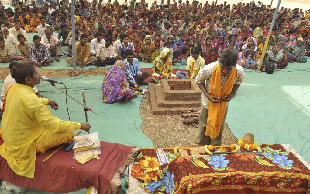 Een Indiaas stamlid neemt in Aranai Village, in de deelstaat Gujarat, deel aan een bekeringsritueel. De ceremonie uit 2014, waarbij ongeveer 200 christenen tot het hindoeïsme overgingen, zorgde voor veel ophef over de vrijwilligheid van zulke bekeringen. beeld Hollandse Hoogte / AFP