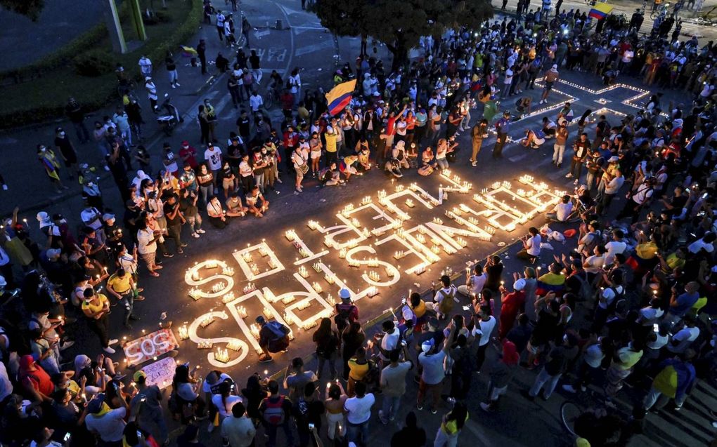 „Voor onze doden”, zo luidt de tekst gevormd door kaarsen. Mensen verzamelden zich woensdag  ter nagedachtenis van de demonstranten die stierven tijdens protesten. beeld AFP, Luis Robayo