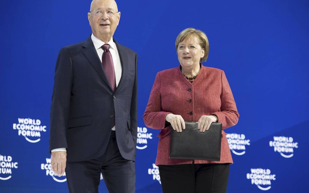 Klaus Schwab samen met Angela Merkel op een bijeenkomst van het World Economic Forum. beeld EPA, Gian Ehrenzeller