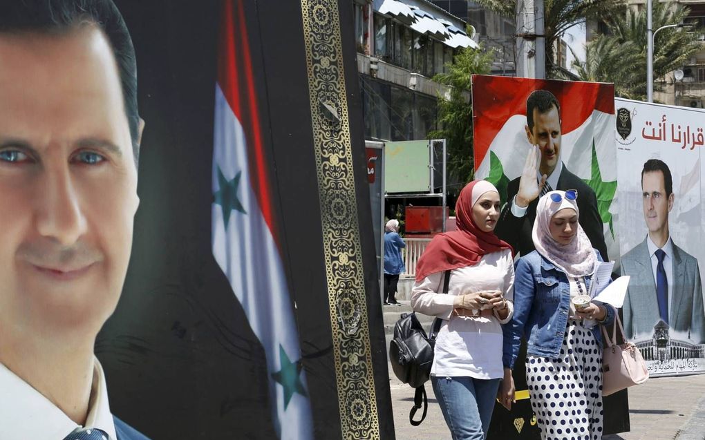 Damascus hangt vol met posters van de zittende president Bashar al-Assad. Hij is zeker van de overwinning van de stembusgang die woensdag plaatsheeft. beeld AFP, Louau Beshara