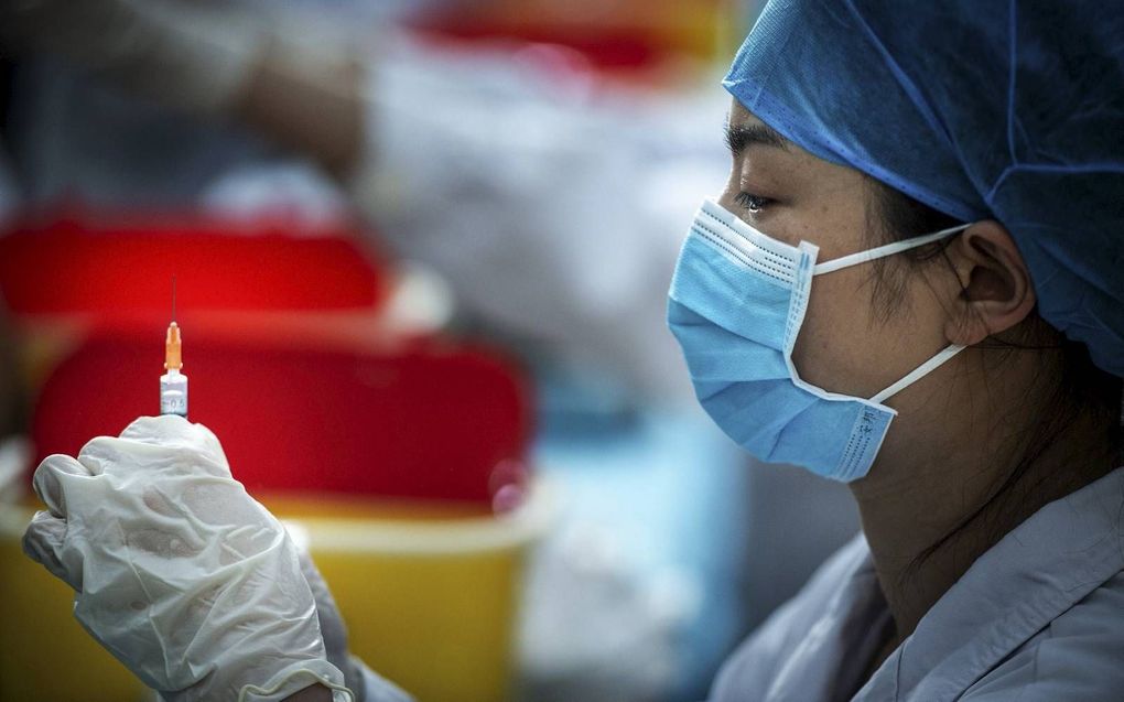 Ook China moest massaal gaan vaccineren om het coronavirus de baas te worden. Een gezondheidsmedewerker in Wuhan was er dit voorjaar nog druk doende mee. beeld AFP, STR