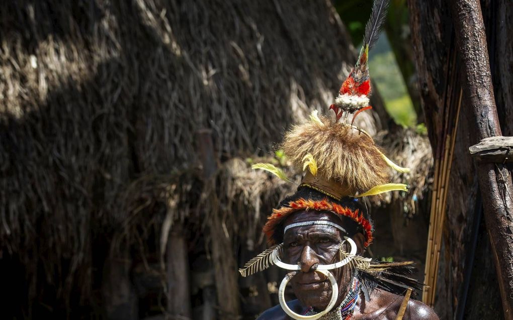 Een inwoner van West-Papoea in traditionele outfit. beeld Guenter Guni