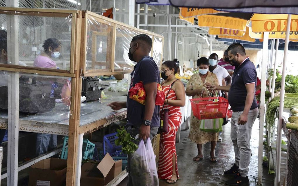 Surinamers stonden maandag in de rij voor winkels in Paramaribo om voedsel te hamsteren. In Suriname is een totale lockdown afgekondigd. Voor de ziekenhuizen geldt code zwart. beeld ANP, Ranu Abhelakh