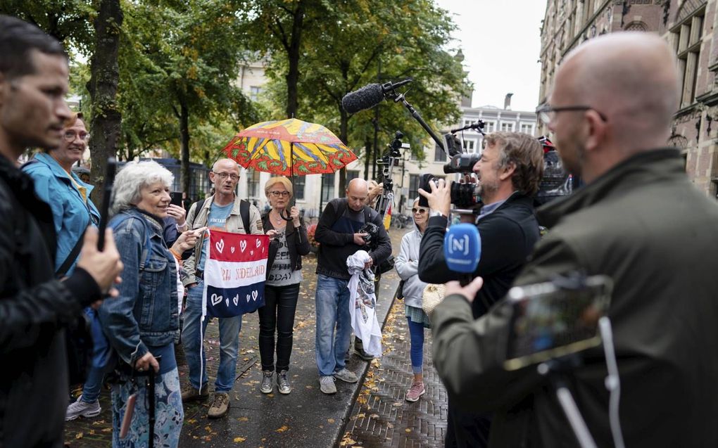 Tegenstanders van de coronamaatregelen en de noodwet gaan in discussie met een cameraploeg, tijdens een demonstratie op het Plein in Den Haag. beeld ANP, Bart Maat