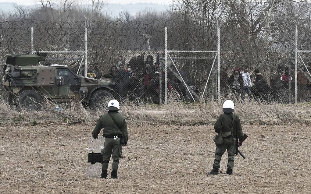 Griekse soldaten houden begin maart 2020 de migranten aan de andere kant van de grens in de gaten. beeld AFP, Sakis Mitrolidis