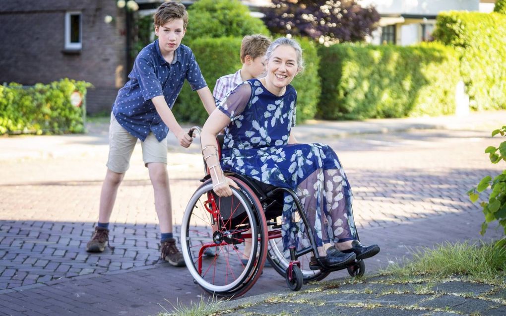 Marianne van der Zalm (49) uit Gorinchem, op de foto vergezeld van haar twee zoons, stuit met haar rolstoel op nogal wat obstakels.  beeld Cees van der Wal